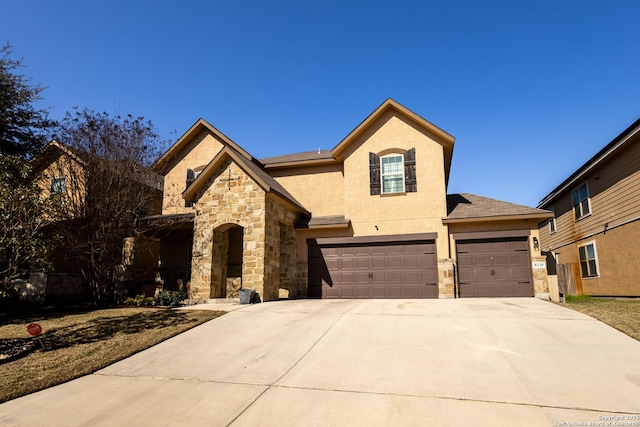 view of front of home featuring a garage, stone siding, driveway, and stucco siding