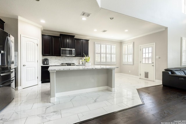 kitchen featuring marble finish floor, stainless steel appliances, a kitchen island, and visible vents