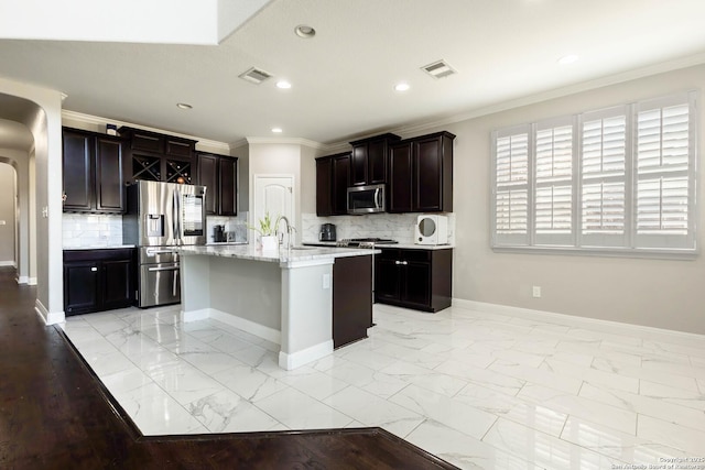 kitchen featuring marble finish floor, stainless steel appliances, visible vents, ornamental molding, and baseboards