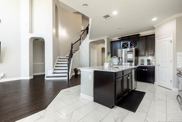 kitchen with stainless steel appliances, arched walkways, marble finish floor, and visible vents