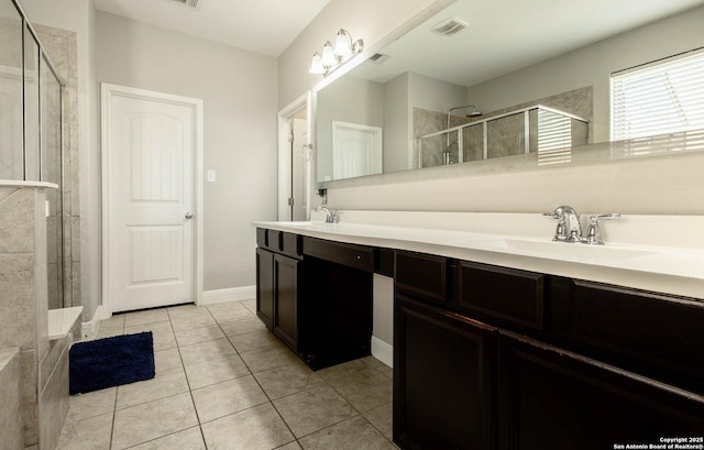 bathroom featuring double vanity, visible vents, a sink, a shower stall, and tile patterned flooring