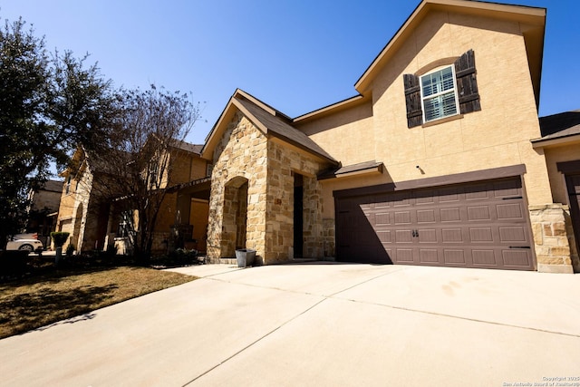 view of front facade featuring a garage, stone siding, driveway, and stucco siding