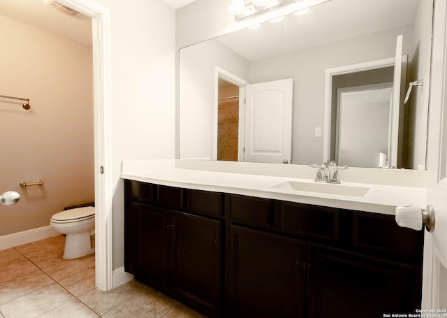 bathroom with toilet, vanity, baseboards, visible vents, and tile patterned floors