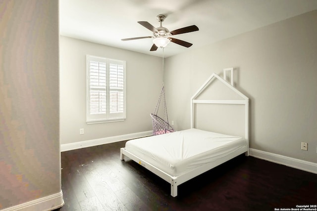 unfurnished bedroom featuring wood finished floors, a ceiling fan, and baseboards