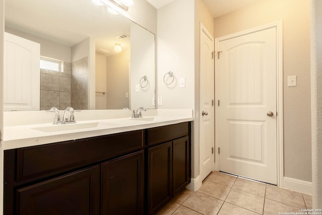 bathroom with double vanity, visible vents, a sink, and tile patterned floors