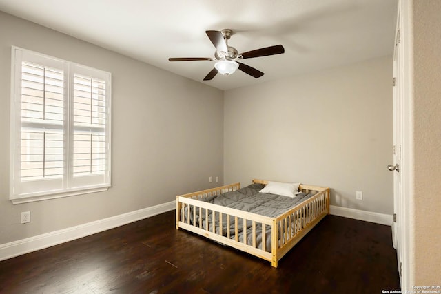 bedroom featuring ceiling fan, baseboards, and wood finished floors