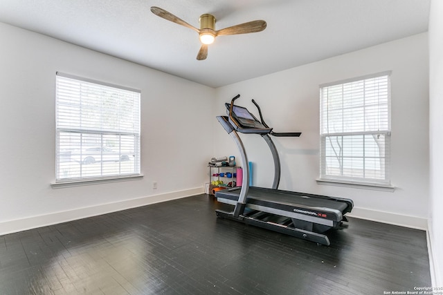 workout area featuring wood finished floors, a ceiling fan, and baseboards