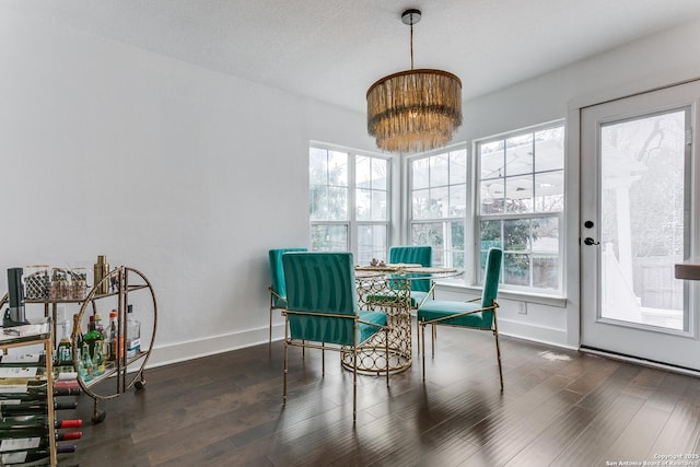 dining space featuring a textured ceiling, baseboards, and wood finished floors