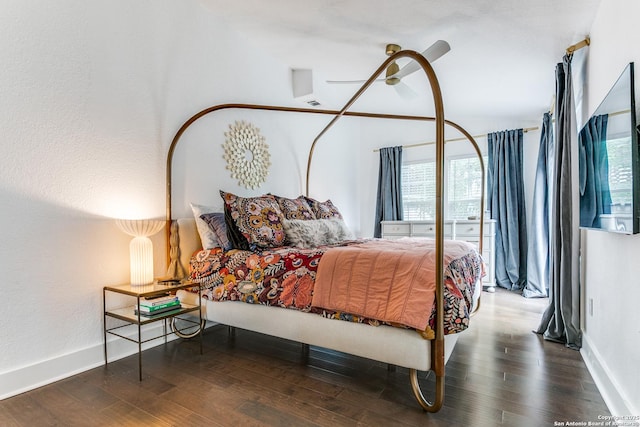 bedroom with a ceiling fan, multiple windows, baseboards, and wood finished floors