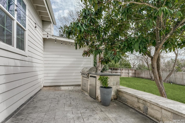 view of patio featuring area for grilling, a fenced backyard, and a grill