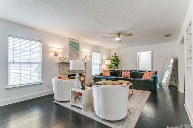 living area with a fireplace, wood finished floors, a ceiling fan, and baseboards