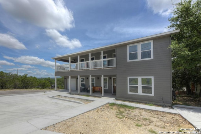 rear view of house with driveway and a balcony