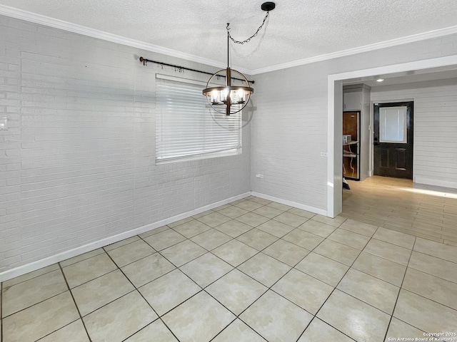 spare room with a textured ceiling, light tile patterned floors, a notable chandelier, brick wall, and ornamental molding