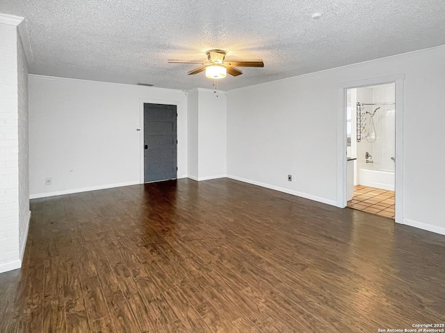 empty room featuring ornamental molding, dark wood-style flooring, ceiling fan, and a textured ceiling