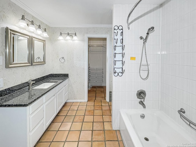 bathroom with a walk in closet, crown molding, washtub / shower combination, vanity, and wallpapered walls