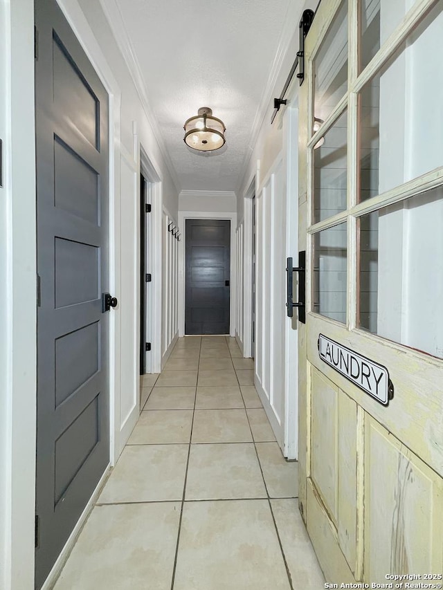 hallway featuring light tile patterned floors and ornamental molding