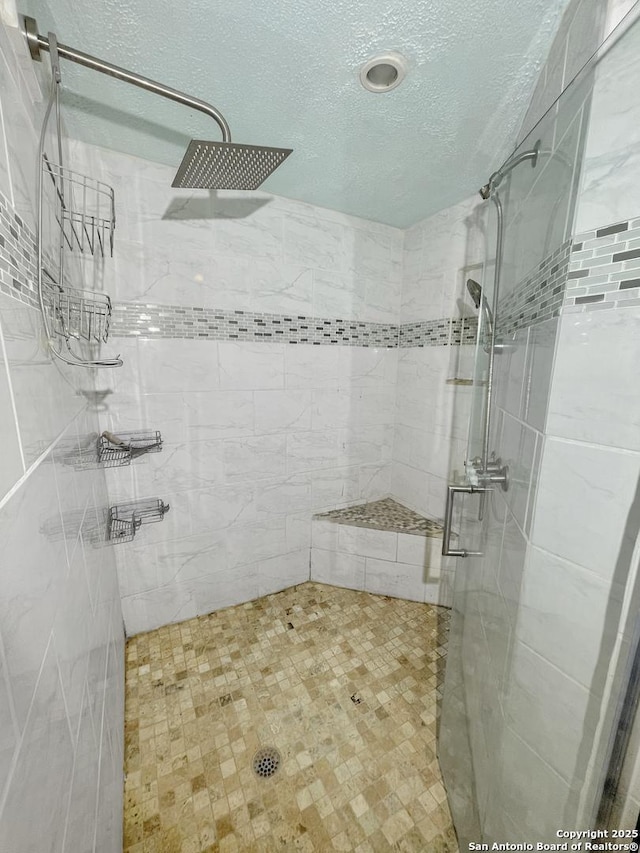 bathroom with a textured ceiling and a shower stall