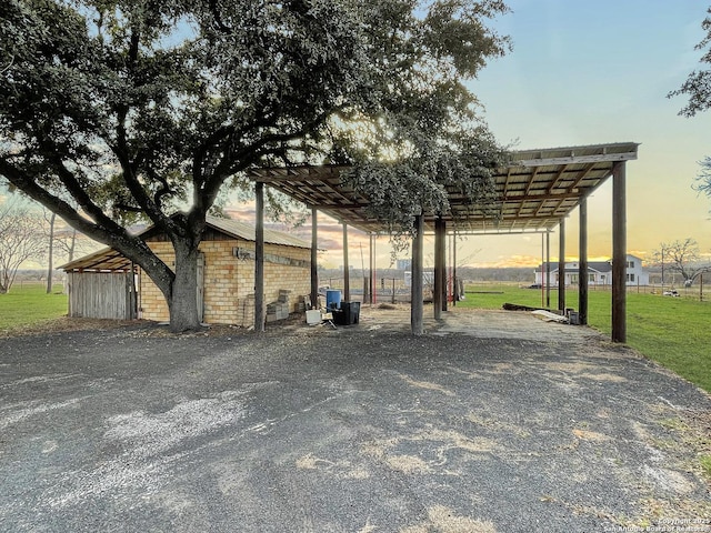 view of car parking with driveway and a detached carport