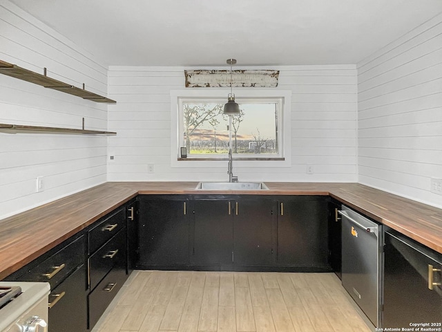 kitchen with butcher block countertops, a sink, dark cabinetry, dishwasher, and open shelves