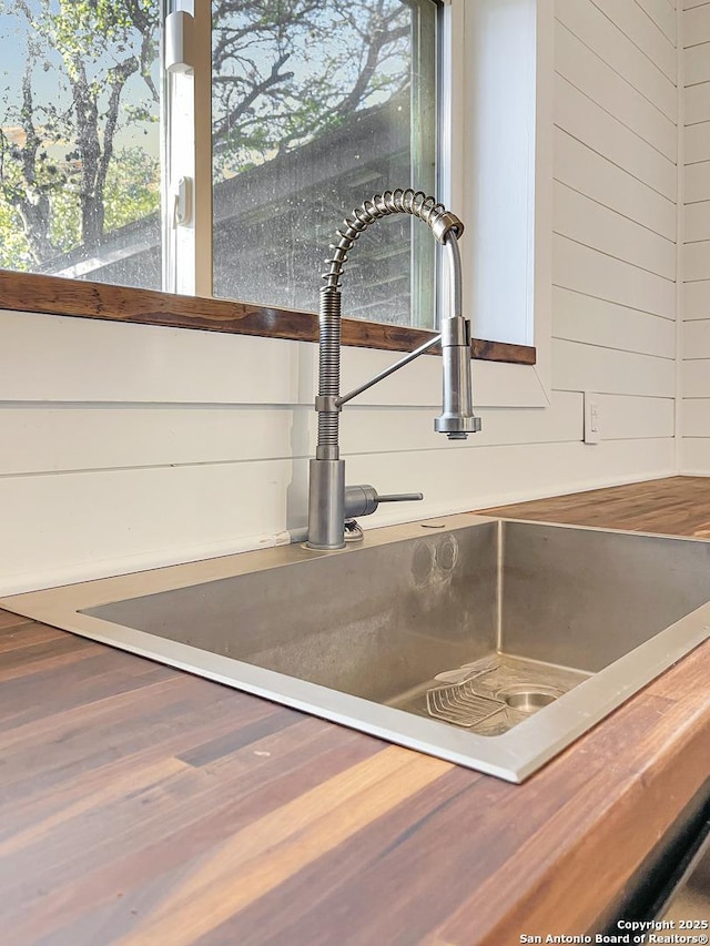 room details featuring a sink and wooden walls