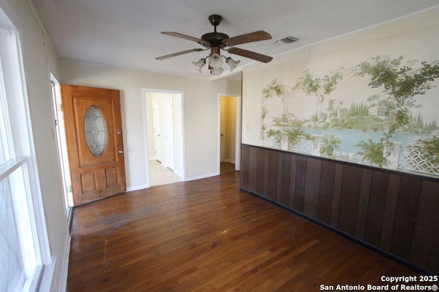 foyer with ceiling fan, visible vents, and wood finished floors