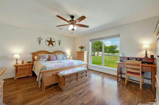 bedroom featuring baseboards, wood finished floors, visible vents, and a ceiling fan