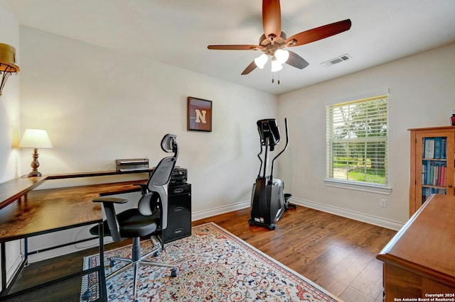 office area with a ceiling fan, baseboards, visible vents, and wood finished floors