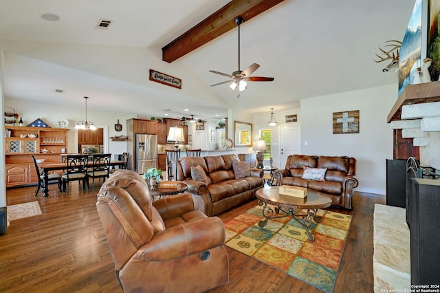 living area featuring ceiling fan with notable chandelier, a fireplace, wood finished floors, and beam ceiling