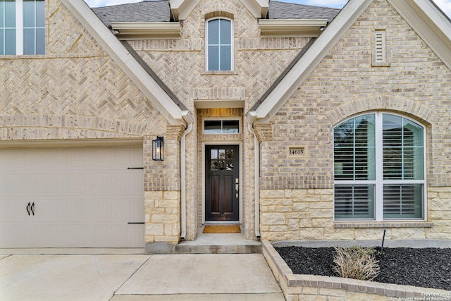 property entrance featuring stone siding, brick siding, concrete driveway, and roof with shingles