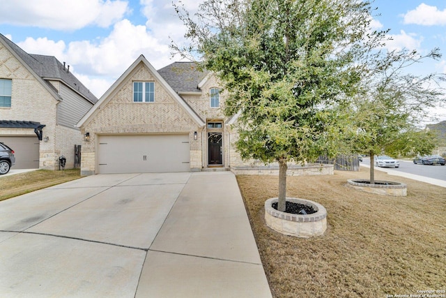 view of front of house featuring a garage, concrete driveway, and brick siding