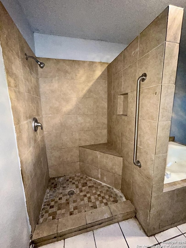 bathroom featuring tiled shower and tile patterned flooring