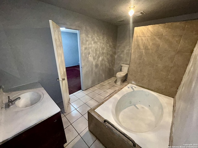 bathroom with visible vents, toilet, vanity, a tub with jets, and tile patterned floors