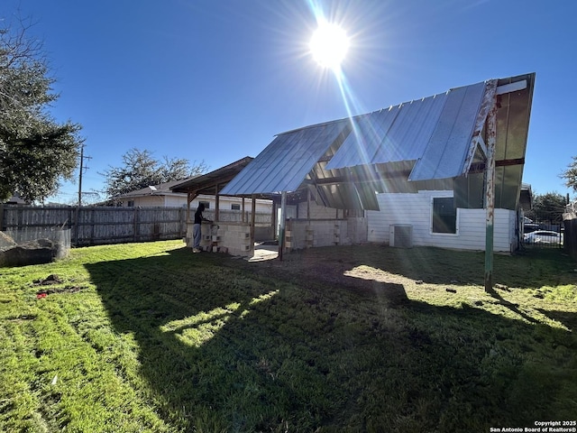 view of yard with an outbuilding, fence, and central air condition unit