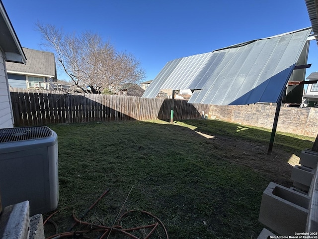 view of yard featuring a fenced backyard and central AC