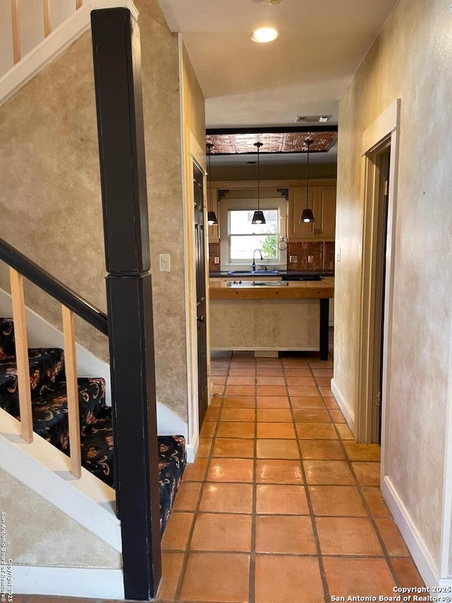 corridor featuring recessed lighting, a sink, and light tile patterned flooring