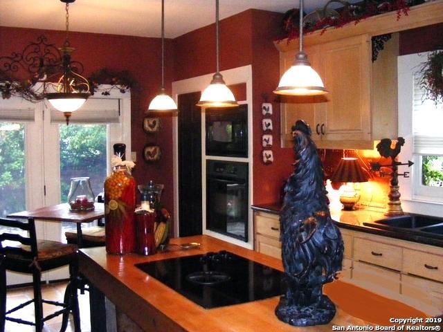 kitchen featuring decorative light fixtures, a sink, and black appliances