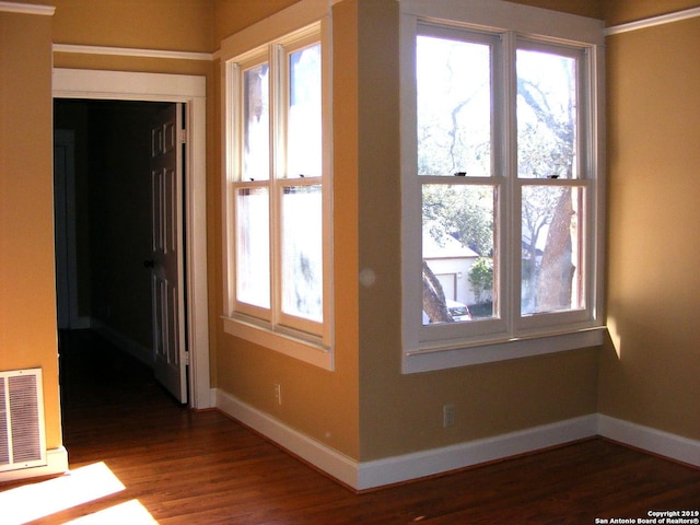 unfurnished room with visible vents, baseboards, and wood finished floors