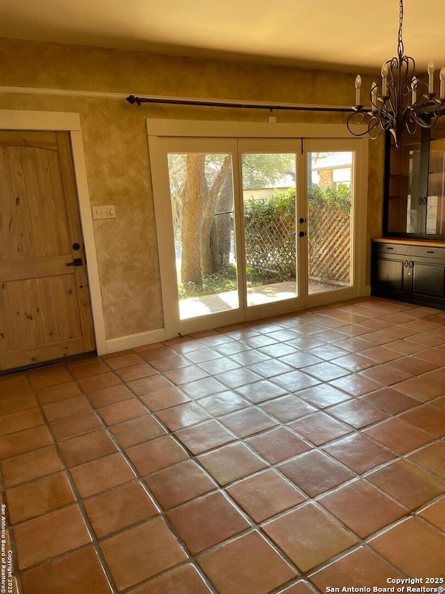 doorway to outside with a notable chandelier and tile patterned floors