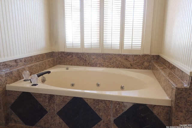 bathroom featuring a tub with jets and a healthy amount of sunlight