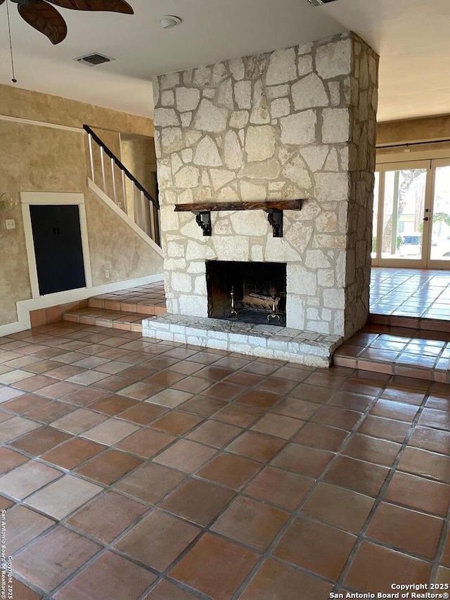 unfurnished living room with french doors, visible vents, a fireplace, and tile patterned floors