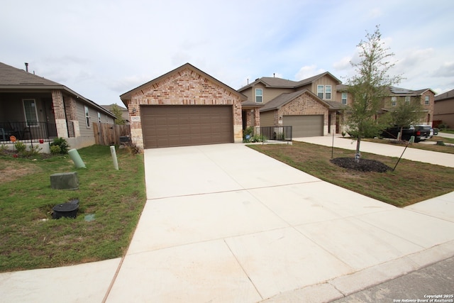 view of front of property featuring brick siding, an attached garage, fence, driveway, and a front lawn