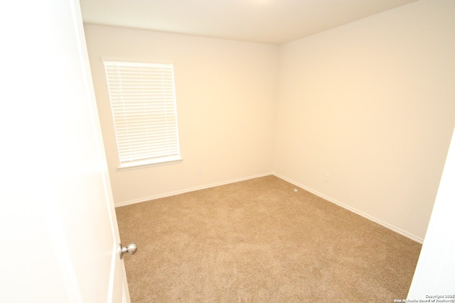 unfurnished room with carpet floors and baseboards