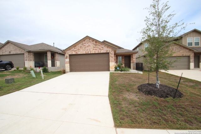 single story home with a front yard, concrete driveway, brick siding, and an attached garage