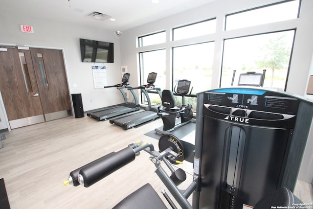 gym featuring baseboards, wood finished floors, and recessed lighting