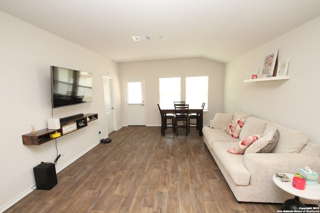 living room with wood finished floors, visible vents, and baseboards