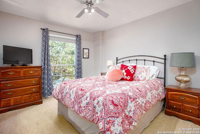 bedroom with a ceiling fan and light colored carpet