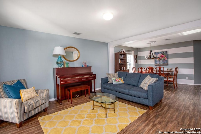 living room featuring visible vents, baseboards, and wood finished floors