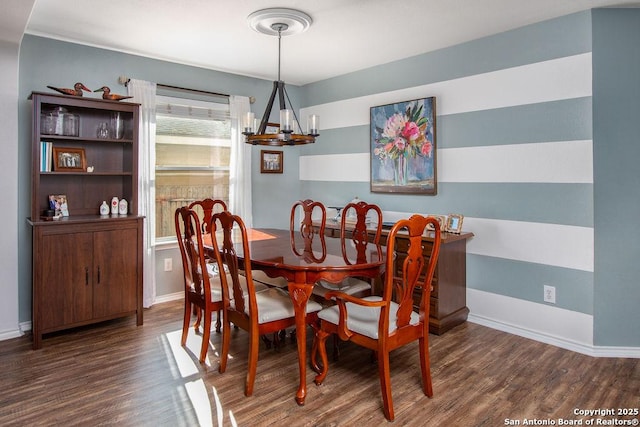 dining room with baseboards, wood finished floors, and an inviting chandelier