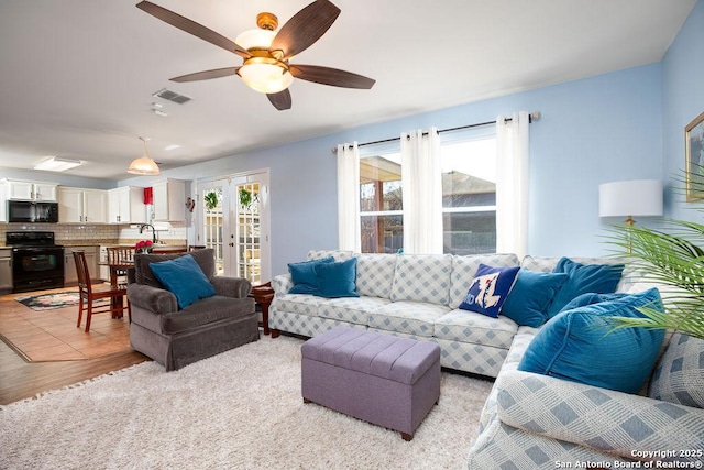 living room featuring french doors, visible vents, and a ceiling fan