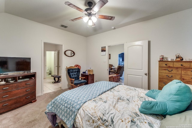 bedroom with light carpet, visible vents, ensuite bath, ceiling fan, and vaulted ceiling